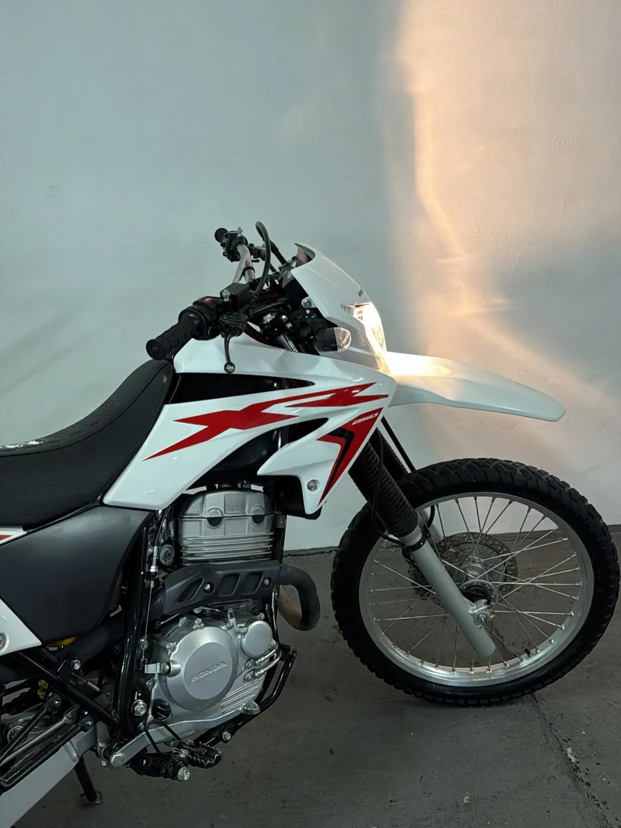 Moto Honda Tornado 250 blanca y roja, vista lateral